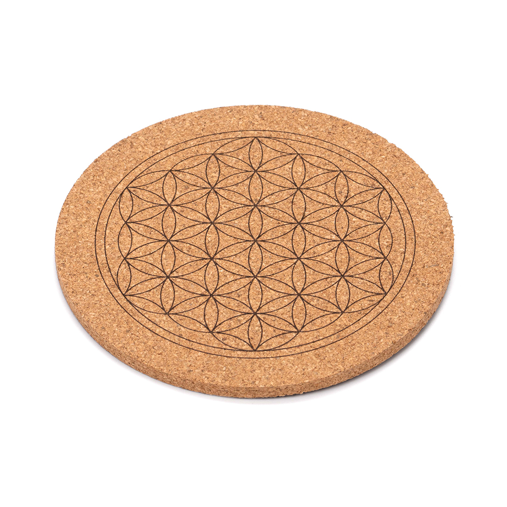 Ein runder Untersetzer aus Kork, in den das geometrische Muster der Blume des Lebens eingraviert ist.