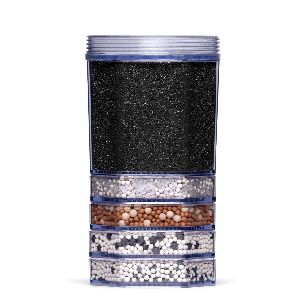 Eine transparente Wasserfilter-Kartusche mit sichtbaren Schichten aus Aktivkohle und verschiedenen Mineralien zur Wasseraufbereitung.
