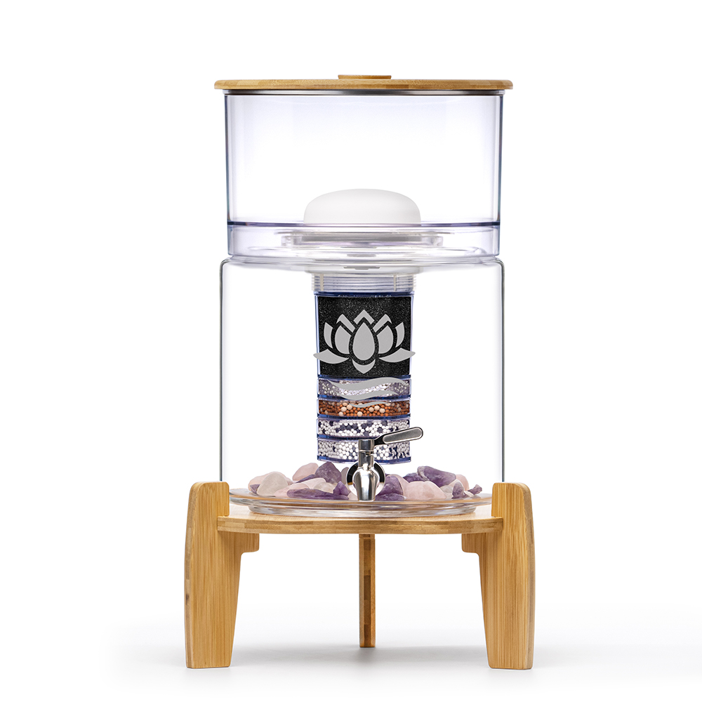 Ein Glas-Wasserspender mit Bambusdeckel und -sockel, der eine mehrstufige Filterkartusche und Mineralsteine enthält.