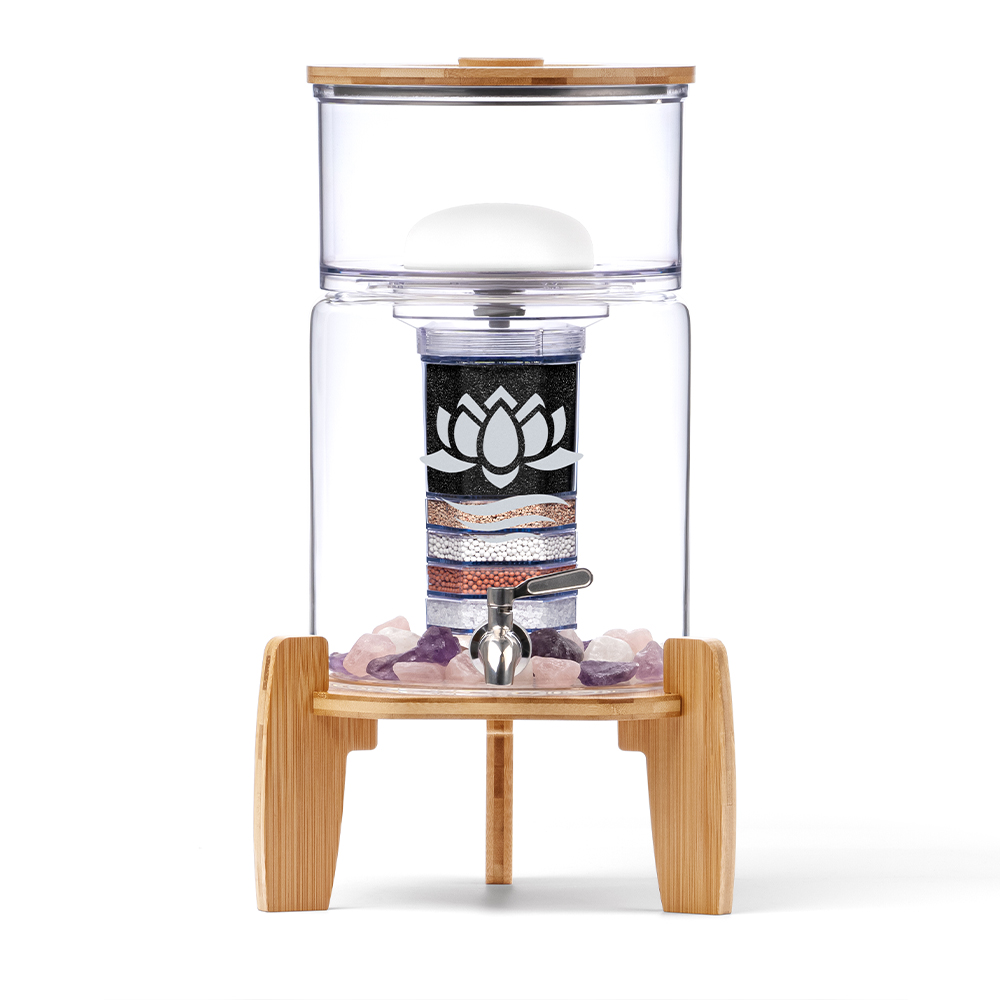 Eleganter Glas-Wasserfilter mit Bambus-Deckel und -Sockel, einem mehrstufigen Filter-System und Edelsteinen im unteren Behälter.
