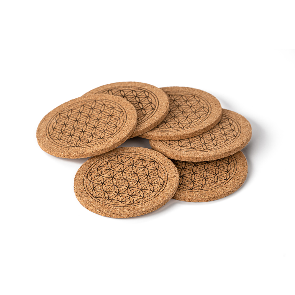 Sechs runde Korkuntersetzer mit eingravierter Blume des Lebens, leicht übereinander gestapelt auf einer weißen Oberfläche.