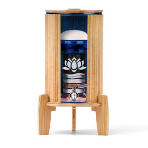Ein Stand-Wasserfilter mit einem Gehäuse und Sockel aus Bambus, einem Behälter aus blauem Glas und einer Schnittansicht, die die inneren Filterstufen und Edelsteine zeigt.