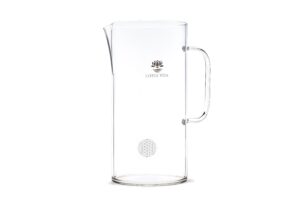 Eine hohe, zylindrische Glaskaraffe mit 3 Litern Fassungsvermögen, Henkel und Ausguss, verziert mit dem Lotus Vita Logo und dem Symbol der Blume des Lebens.