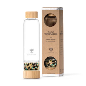 Eine Glas-Trinkflasche mit Bambusdeckel und einem separaten Bodenfach, gefüllt mit einer Mischung aus goldenen, schwarzen und türkisfarbenen Edelsteinen, steht neben ihrer Kartonverpackung.
