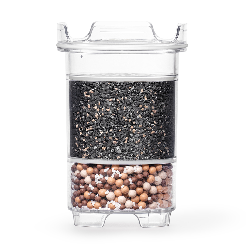 Eine transparente Wasserfilter-Kartusche, die im oberen Bereich mit Aktivkohle und im unteren Bereich mit Mineralkugeln gefüllt ist.